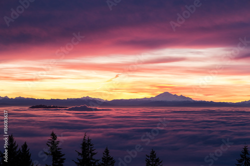 Low clouds moving like ocean wave with Mountain Baker in the background at sunrise in Vancouver  BC