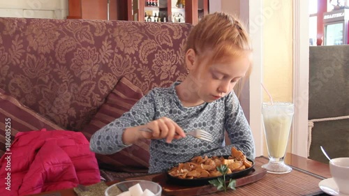 Beautiful red-haired girl in a cafe