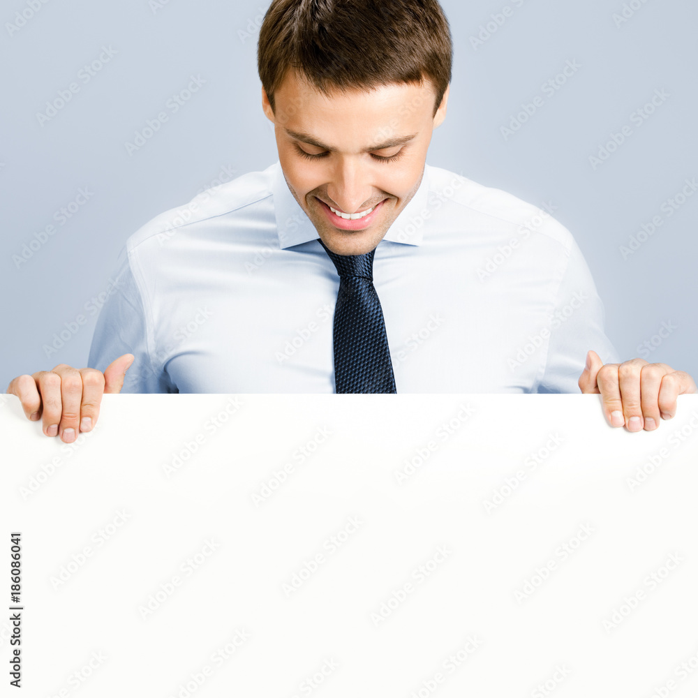 Business man showing blank signboard, over grey Business man showing blank signboard, over grey