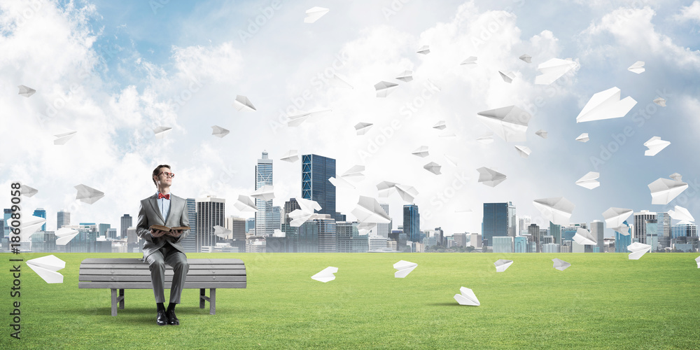 Young businessman or student studying the science and paper planes flying around Young businessman or student studying the science and paper planes flying around