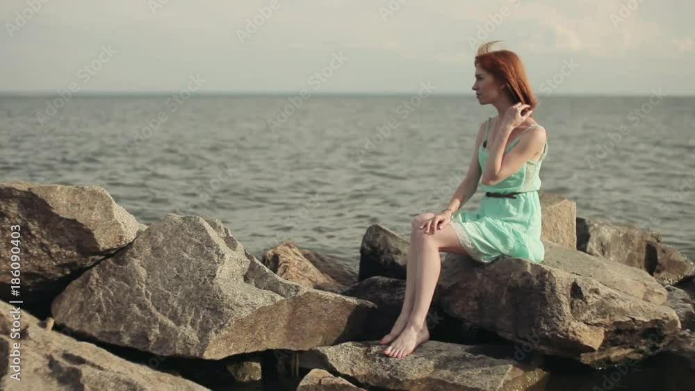 beautiful sexy girl sits on the rocks on the sea beautiful sexy girl sits on the rocks on the sea