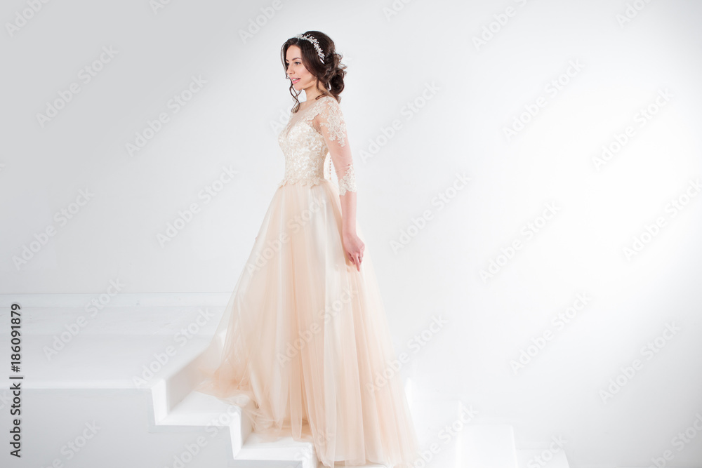 Portrait of a beautiful girl in a wedding dress. Concept of bride going towards future happiness, white background