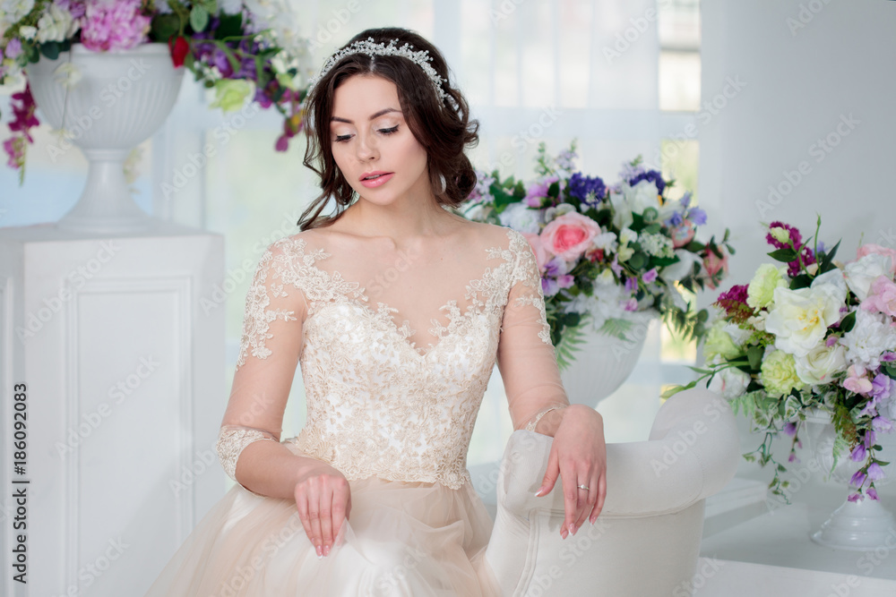 Portrait of beautiful girl in a luxurious wedding dress. Interior decorated with flowers Portrait of beautiful girl in a luxurious wedding dress. Interior decorated with flowers