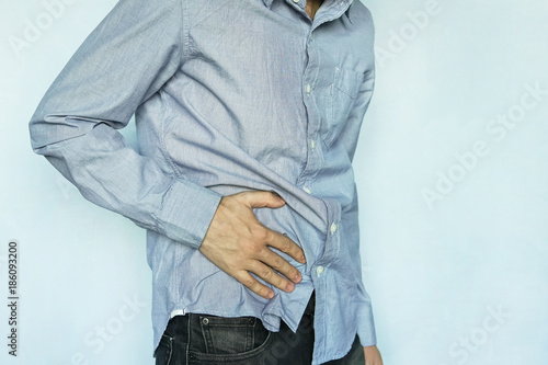 Man with stomach pain on blue background photo