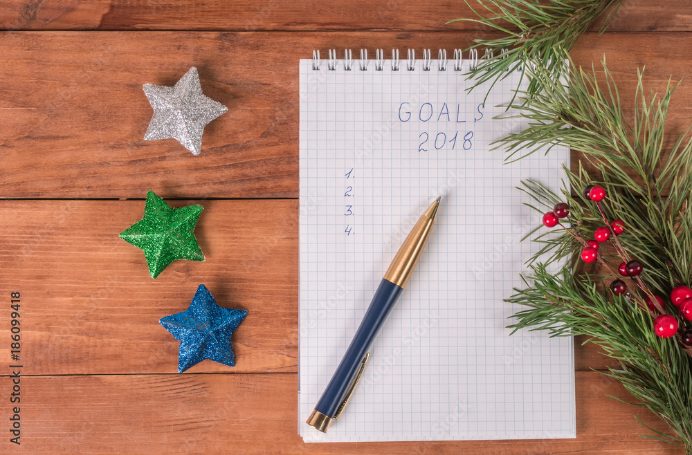 Notepad and Christmas tree decorations on a wooden background Notepad and Christmas tree decorations on a wooden background