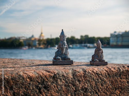 Small sphinxes stand on the embankment of the Neva River with a view of St. Petersburg