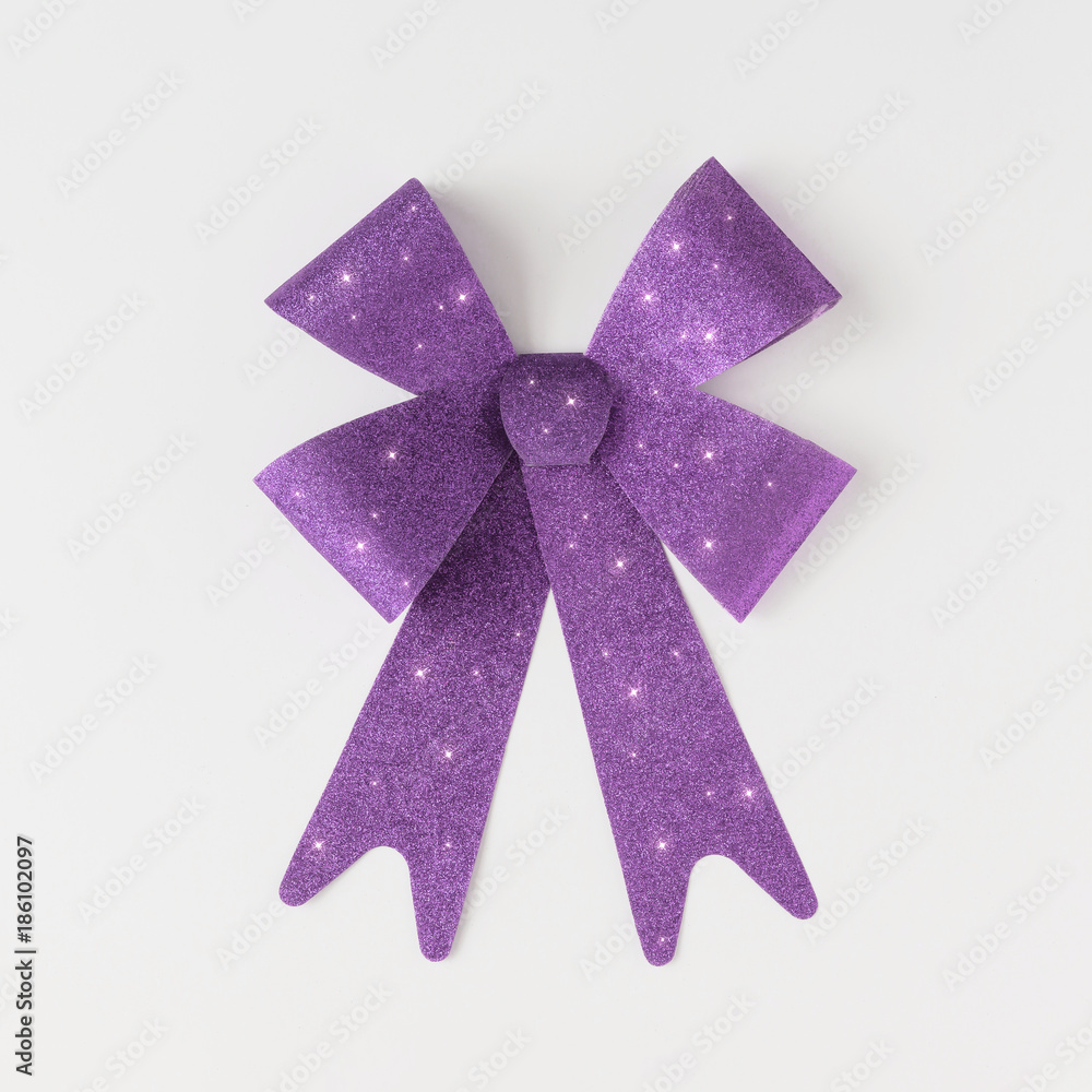 Minimal violet gift bow on bright background. Flat lay. Minimal violet gift bow on bright background. Flat lay.