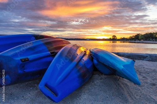 Summer Lake Sunrise Background. Kayaks line the lakeshore with vibrant and beautiful sunrise colors in the background. Grand Traverse Bay in Traverse City, Michigan, USA. photo