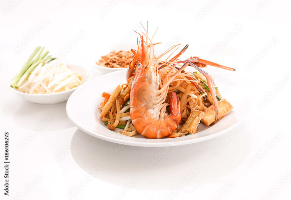 Thai cruisine - Pad Thai, stir-fried rice noodle dish with shrimp, egg and side dishes Thai cruisine - Pad Thai, stir-fried rice noodle dish with shrimp, egg and side dishes