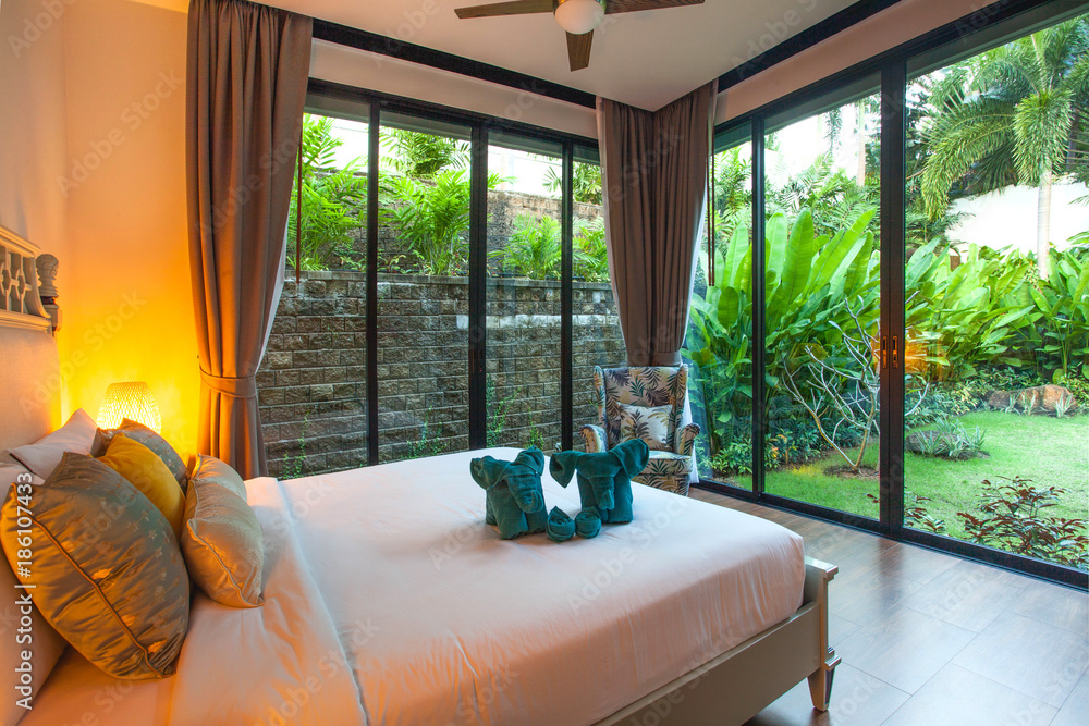 Luxury Interior design in bedroom of pool villa with cozy king bed. Bedroom with high raised ceiling Luxury Interior design in bedroom of pool villa with cozy king bed. Bedroom with high raised ceiling