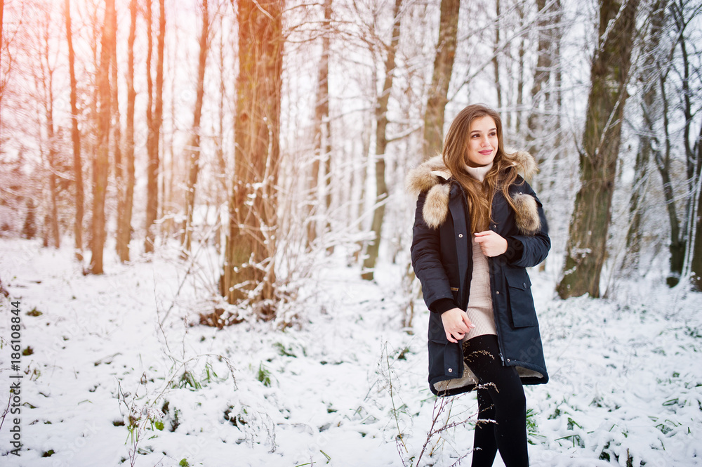 Beautiful brunette girl in winter warm clothing. Model on winter jacket.