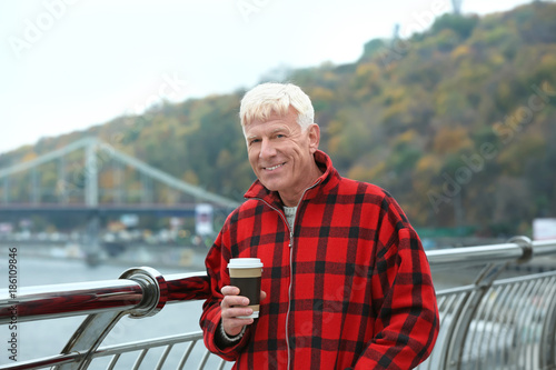 Handsome mature man with coffee outdoors