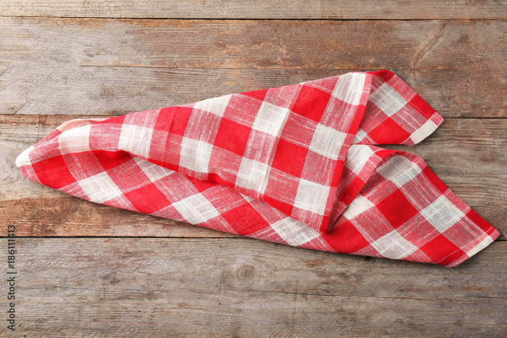 Checkered kitchen towel on wooden background Checkered kitchen towel on wooden background