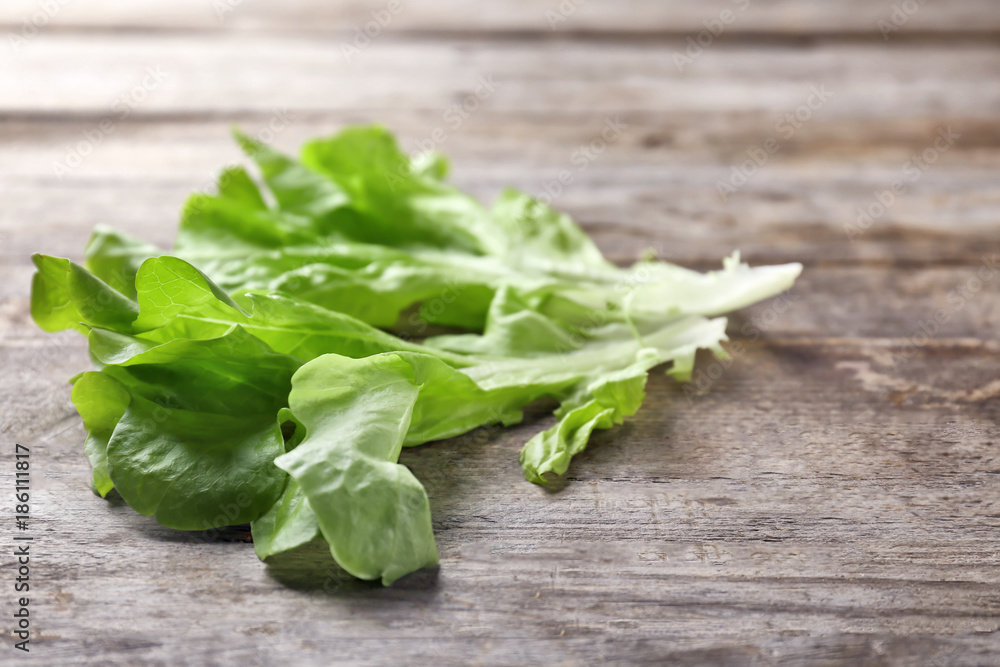 Leaves of fresh green salad on wooden table Leaves of fresh green salad on wooden table