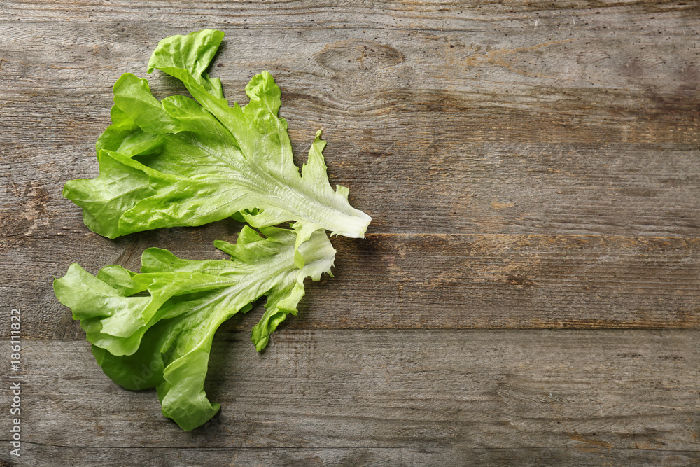 Leaves of fresh green salad on wooden table Leaves of fresh green salad on wooden table