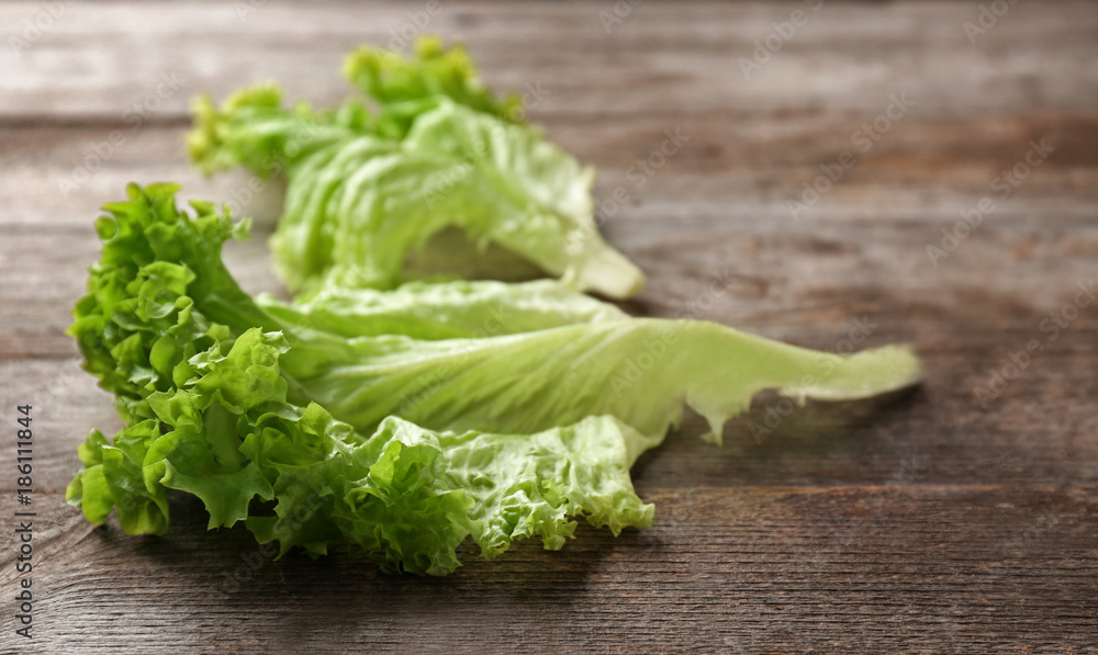 Leaves of fresh green salad on wooden table Leaves of fresh green salad on wooden table
