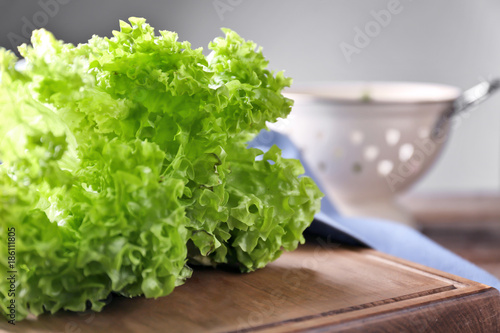 Photography Bunch of fresh green salad on wooden board, closeup
