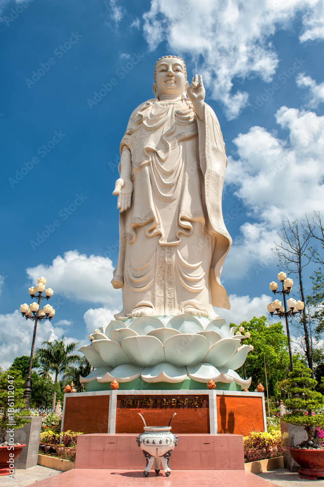 Huge Buddha statue in the garden of the famous Vinh Trang Pagoda at My Tho City, Vietnam