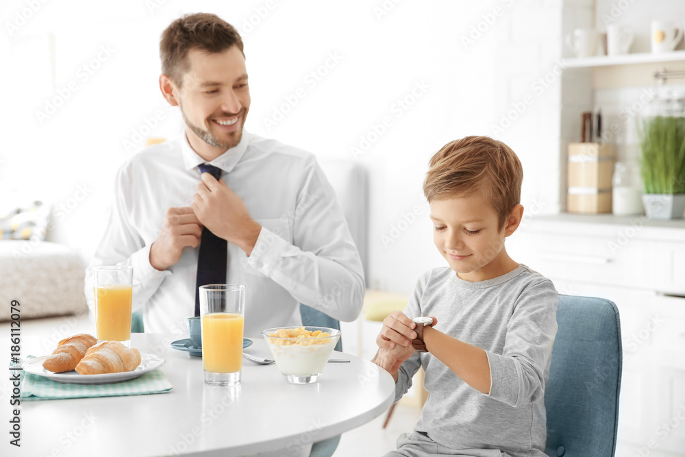 Father with son having breakfast in kitchen