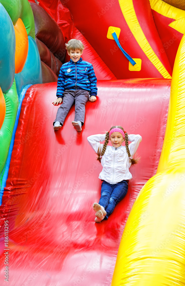Brother and sister have fun in slide