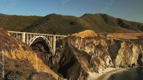 a wide angle panning shot of bixby bridge on highway 1 along the california coast in big sur
