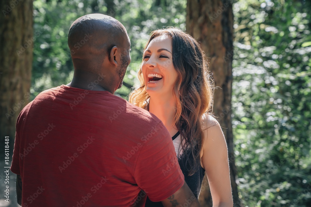 Fototapeta premium Husband and wife embracing and laughing in park 