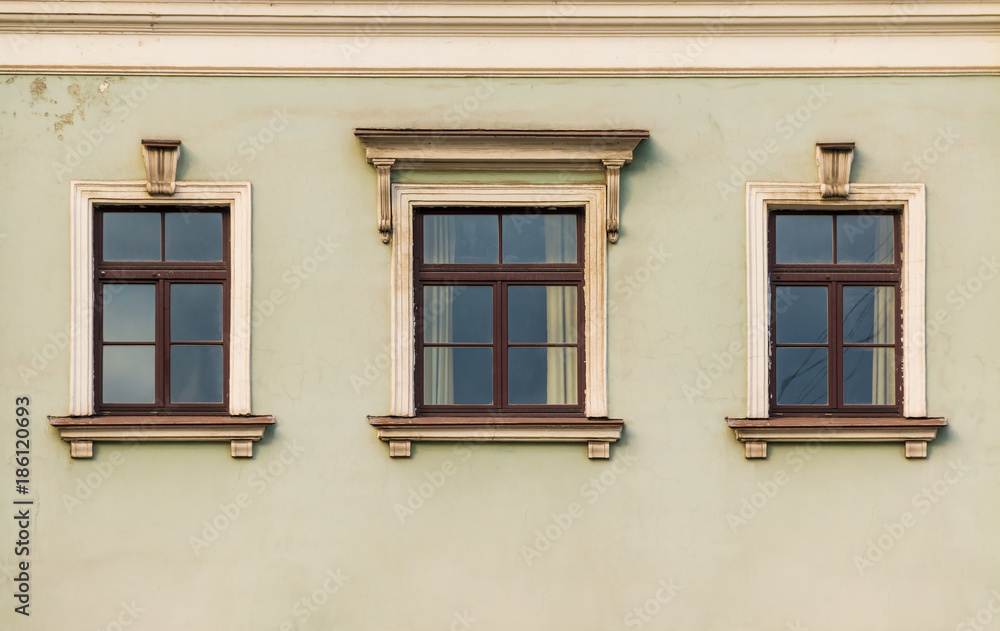 Three windows in a row on the facade of the urban historic building front view, Saint Petersburg, Russia
