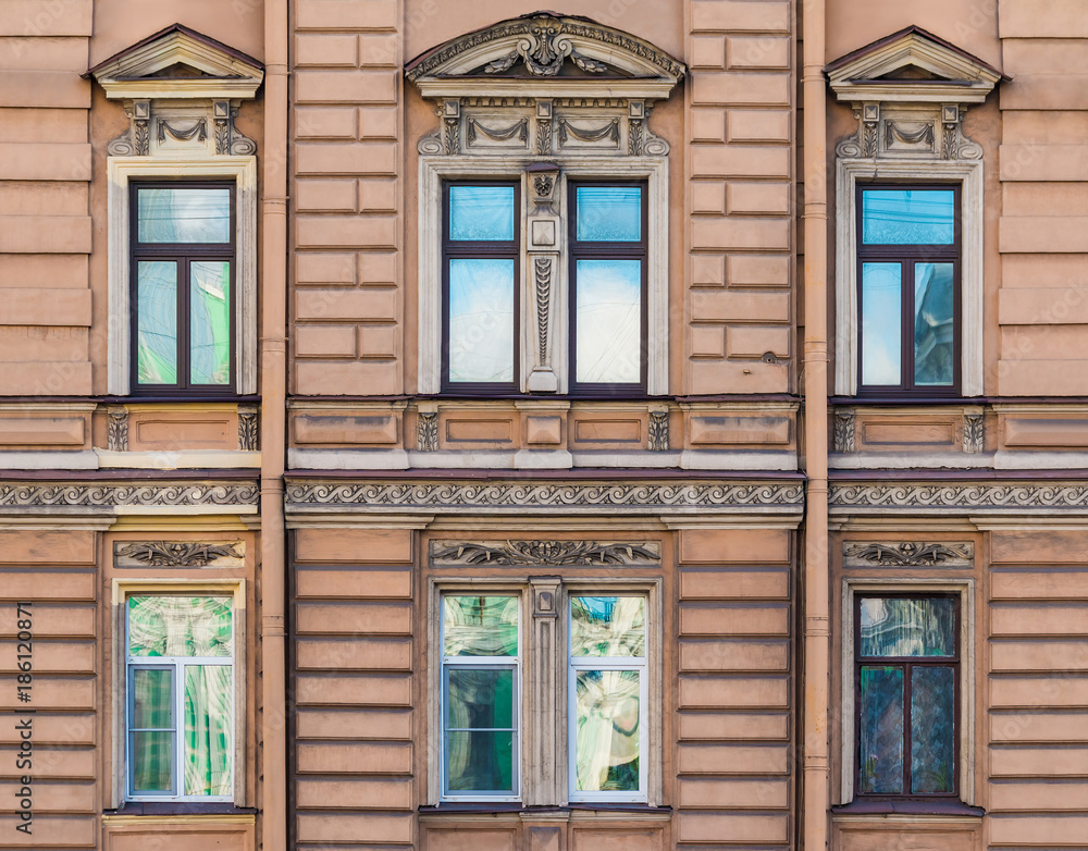 Several windows in a row on the facade of the urban historic building front view, Saint Petersburg, Russia
