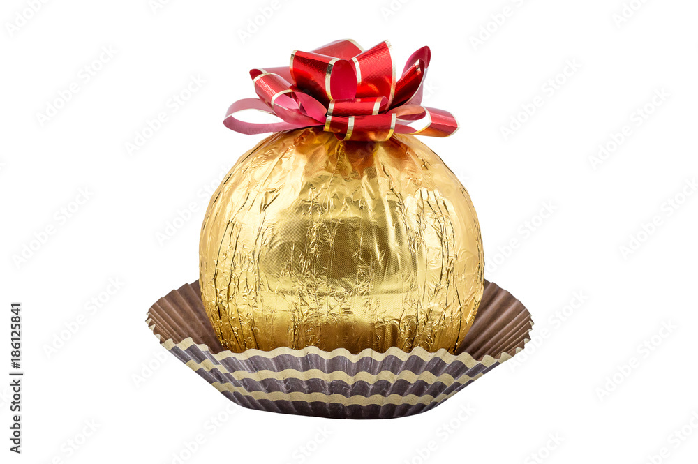 Big round candy in golden foil with bow. Isolated on white.