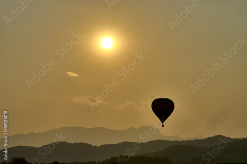 Lonely flight - hot air balloon above the mountains at the evening.