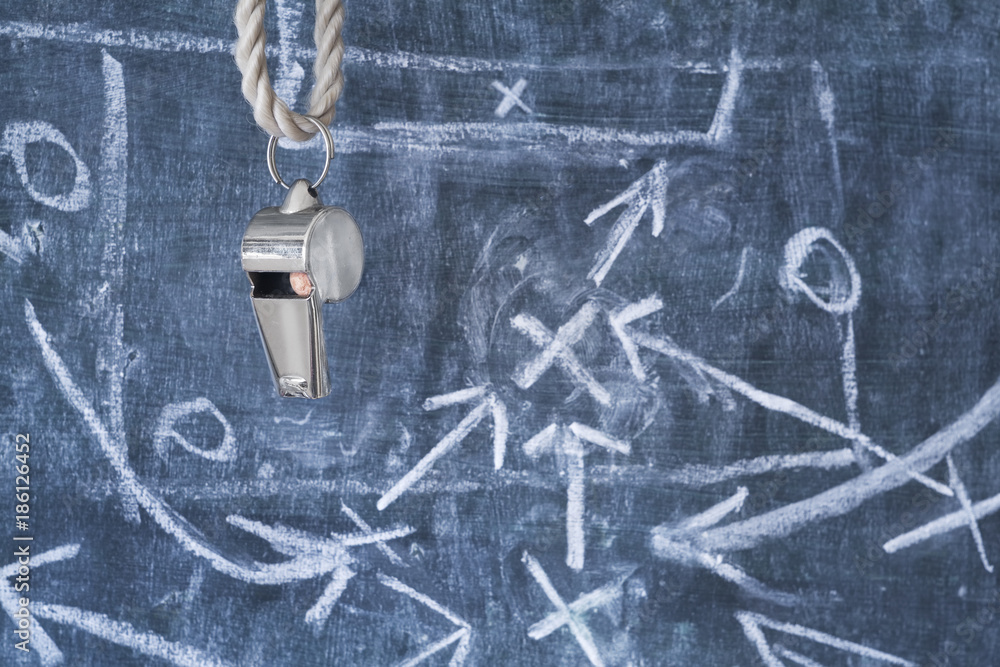 whistle of a soccer coach or referee on black board with strategy drawing whistle of a soccer coach or referee on black board with strategy drawing