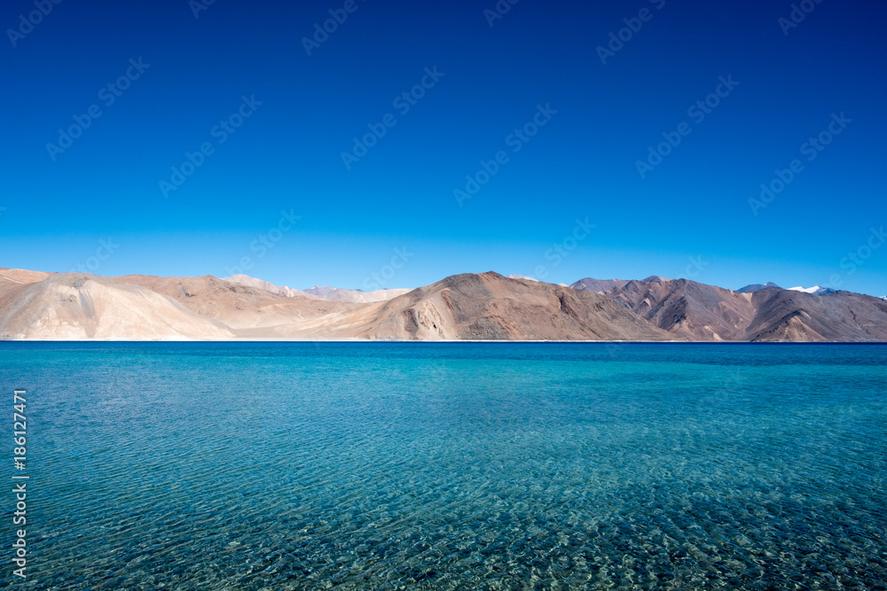 Fototapeta premium Landscape image of Pangong lake with mountains view and blue sky background