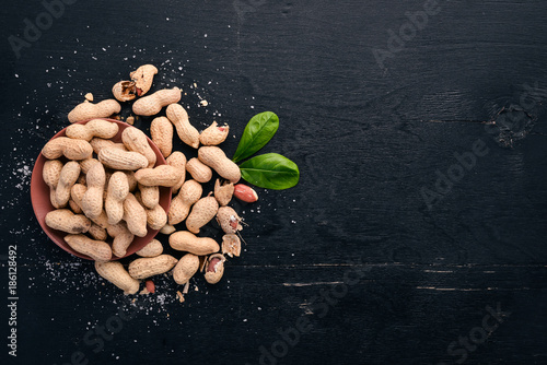Peanuts on a dark wooden background. Healthy snacks. Top view. Free space for text.