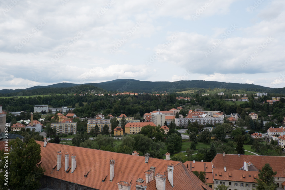 View of the medieval town of Cesky Krumlov, Czech Republic. Quaint European town on an overcast day. Cityscape of Cesky Krumlov from a hill, overlooking the red roofed town below.