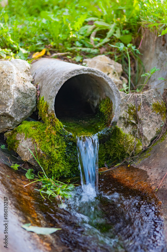 pipe from the ground flowing ecological clean water © dbrus
