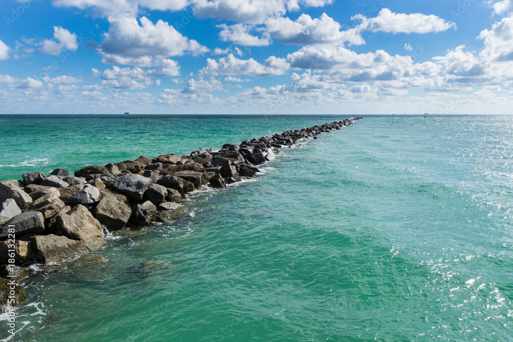 USA, Florida, Miami beach mole of rocks in the turquoise ocean