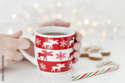 Female hand holding cup of tea in winter, holidays concept, Christmas mood