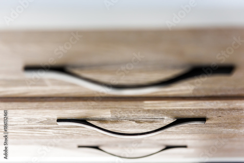 Closeup of modern light wooden chest drawer in bedroom with natural light in staging home, house or apartment model