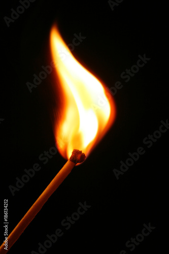 burning matchstick on black background