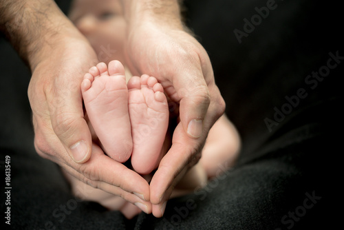 Newborn Baby feet in parents' hands - happy family moments of parents with their children