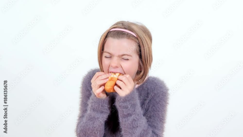A young girl is stuffing her face with a lot of bread. A young girl is stuffing her face with a lot of bread.