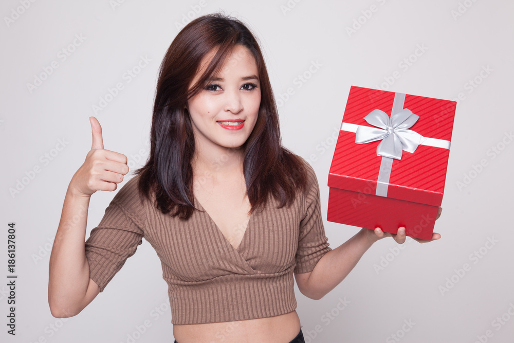 Asian woman thumbs up with a gift box.