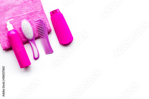 Basic hair care in bathroom. Comb, shampoo, spray, towel on white background top view copyspace