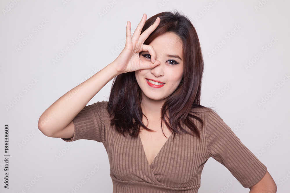 Beautiful young Asian woman show OK sign over her eye. Beautiful young Asian woman show OK sign over her eye.