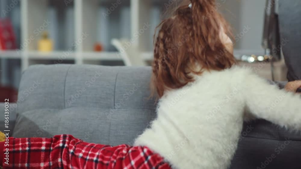 Portrait cute little girl playing jumping with pillow on the sofa in home child childhood happy room apartment bedtime casual slow motion Portrait cute little girl playing jumping with pillow on the sofa in home child childhood happy room apartment bedtime casual slow motion