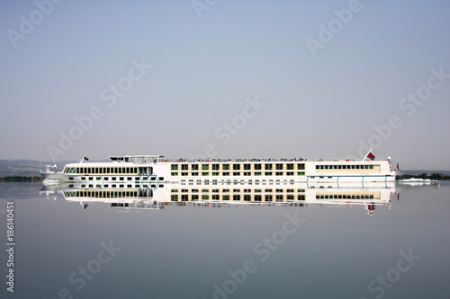  River cruises boat with mirror reflection on the clear surface of water