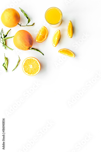 Orange juice in glass near slices of oranges on white background top view copyspace