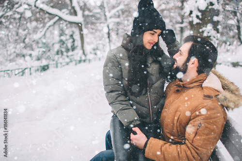 Wallpaper Mural Happy Young Couple in Winter . Family Outdoors. man and woman looking upwards and laughing. Love, fun, season and people - walking in winter park. Female model sits on his lap. Torontodigital.ca