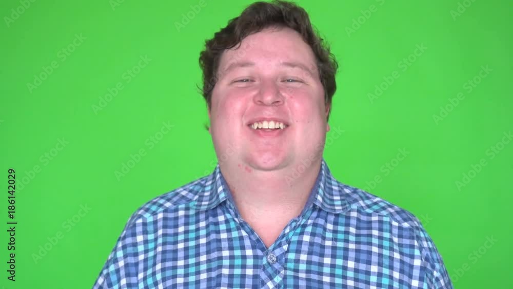 Fat man smiles and laughs, on a green screen studio background Fat man smiles and laughs, on a green screen studio background
