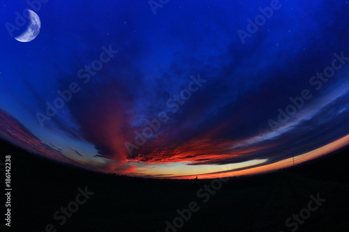 Fototapeta Naklejka Na Ścianę i Meble -  Księżyc i czerwone chmury po zachodzie słońca, rybie oko.